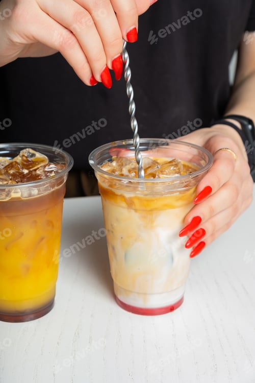 Visualização: As mãos do barista preparam coquetéis de verão com gelo e café