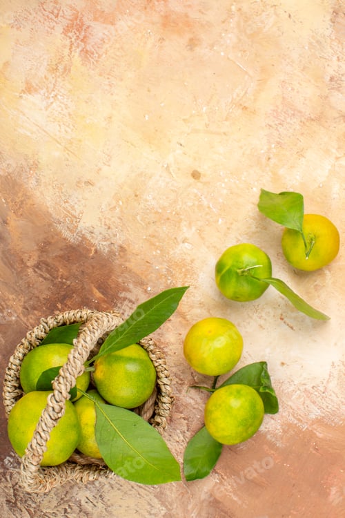 Preview: top view fresh green tangerines inside basket on a light background photo color mellow fruit juice