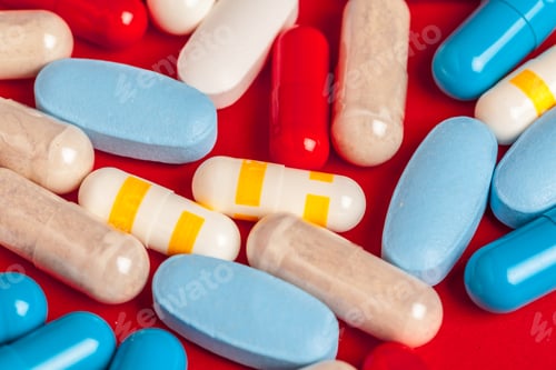 Preview: Many medicine pills close up on red background