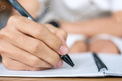 Preview: Young Businesswoman writing something on notebook in office or cafe
