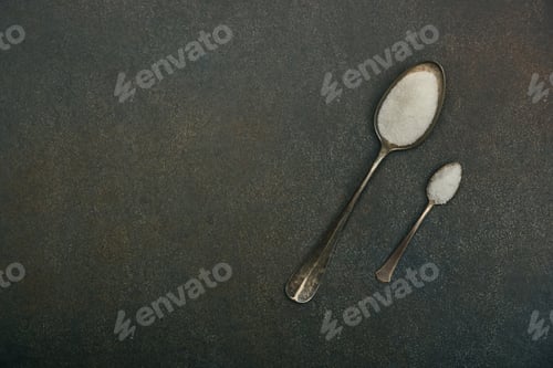Preview: Two spoons of sugar and salt on table