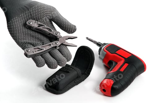 Preview: A Man Disassembles Folding Pliers. In The Background Is An Electric Screwdriver. Multi-Tool. A Home