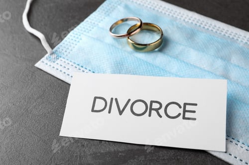 Preview: Composition protective mask and wedding rings on grey table. Divorce during coronavirus quarantine