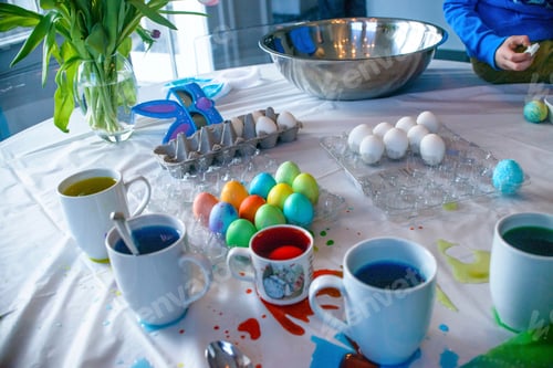 Preview: Cropped shot of boy dyeing eggs at table for Easter