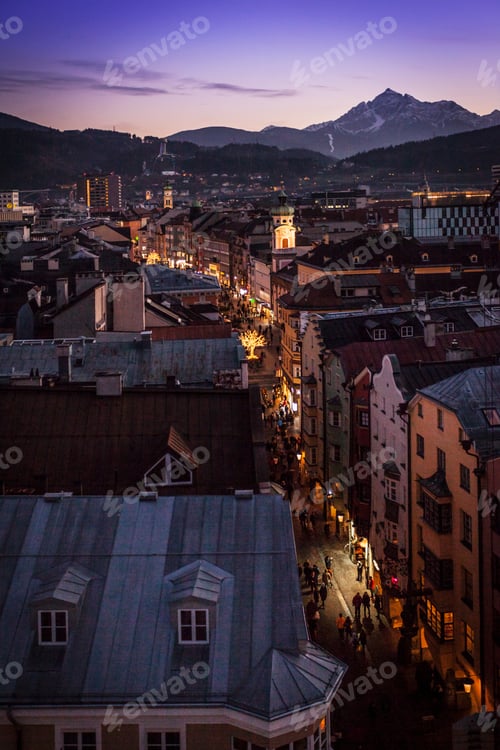 Preview: Elevated cityscape with crowds strolling christmas market street at night, Innsbruck, Austria
