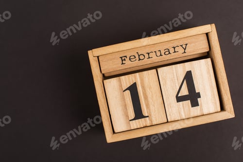 Preview: close up of wooden calendar with cubes and 14 february lettering on black