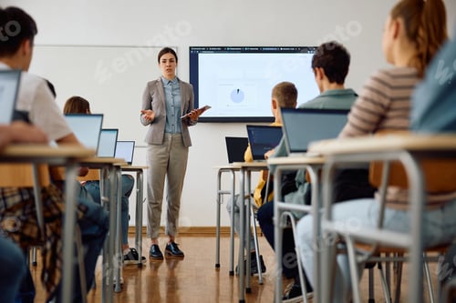 Preview: Female professor talking to her students during IT class at high school.