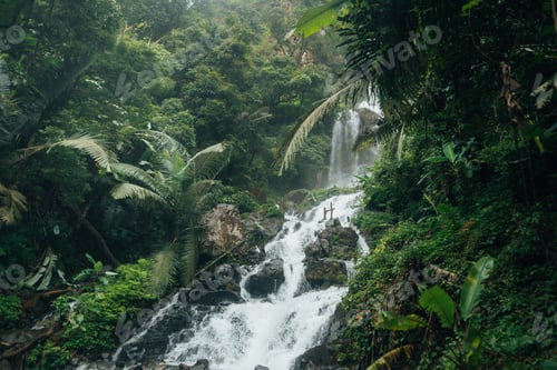 Preview: A beautiful waterfall cascades down from a rocky cliff amidst lush greenery