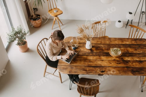 Preview: Woman Works at Rustic Table in Sunny Room