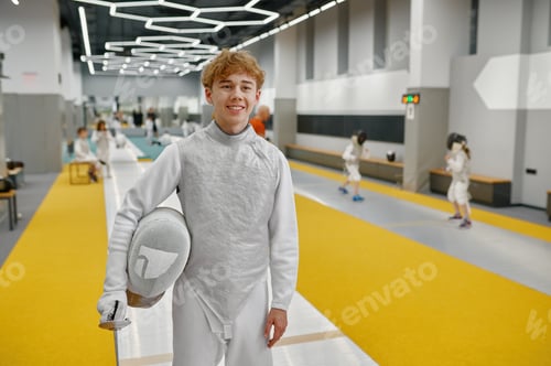 Preview: Happy smiling young fencer portrait over gym interior of martial sport school