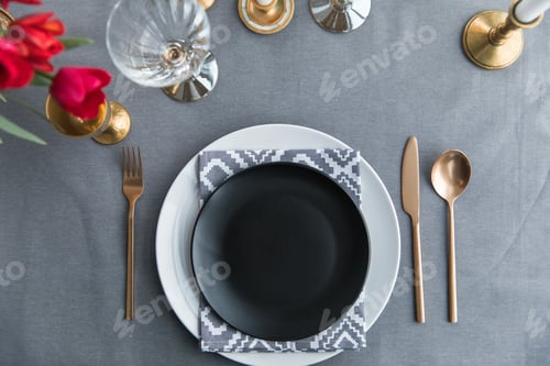 Preview: top view of black empty plate, napkin and old fashioned tarnished cutlery on tabletop