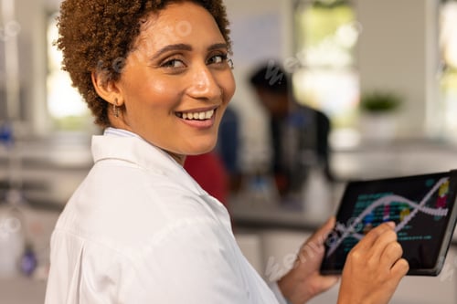 Preview: In high school, smiling teacher using tablet to study DNA structure in science lab