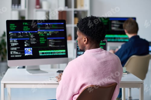 Preview: Young Black Man Writing Code on Computer in Office Setting