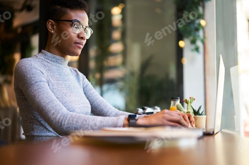 Preview: Focused female employee working on laptop
