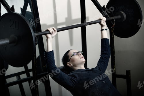 Preview: Modern businesswoman in gym doing exercise