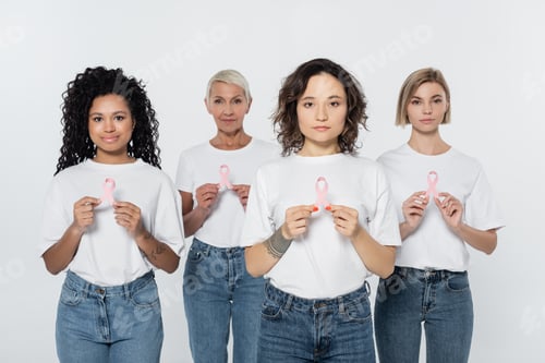 Preview: Woman holding pink ribbon of breast cancer awareness near interracial friends isolated on grey