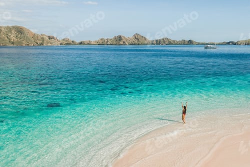 Preview: Tropical vacations concept. Happy woman enjoying on beach with amazing mountain view and clear