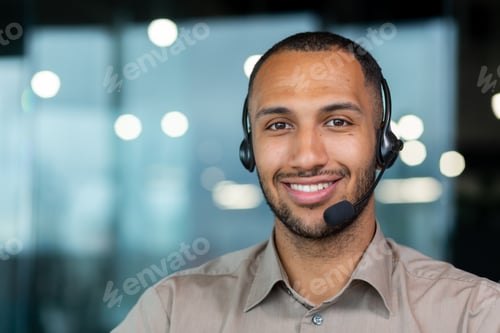 Preview: Close up hispanic male worker with video headset smiling and looking at camera, tech support worker
