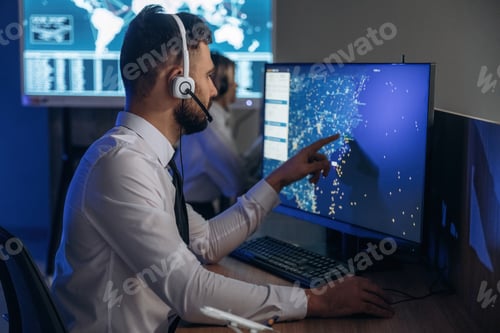 Preview: In headphones. People are working by computers in airline company