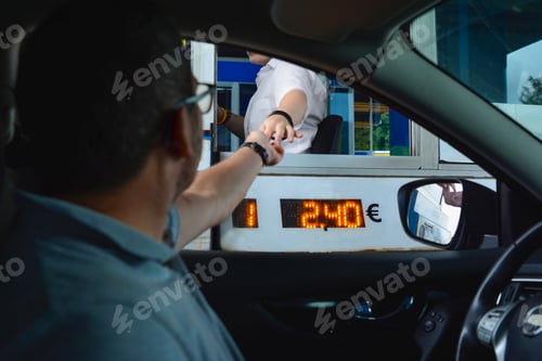 Preview: A man pays money to a cashier for a toll road