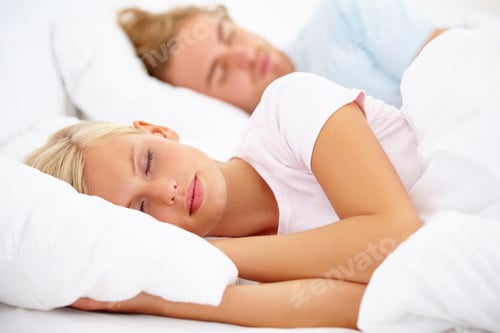 Preview: Catching some shut eye. A young couple sleeping in bed together.