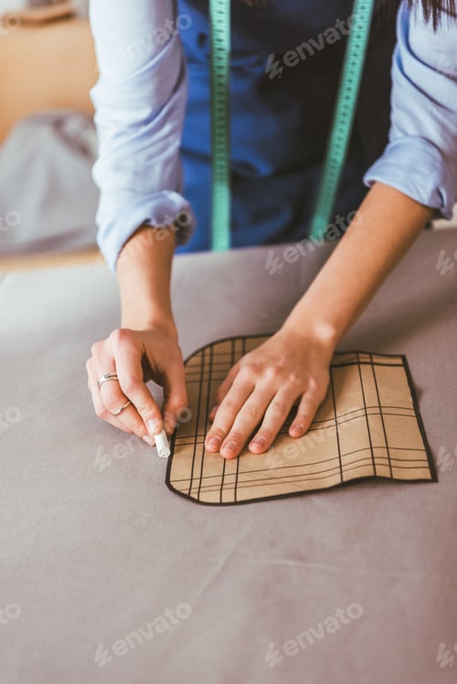 Preview: cropped image of beautiful seamstress making pattern with piece of chalk on fabric