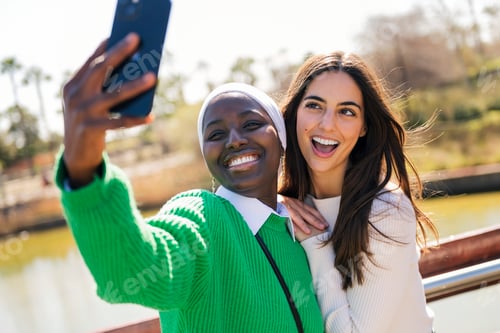 Preview: female friends having fun taking selfie with phone
