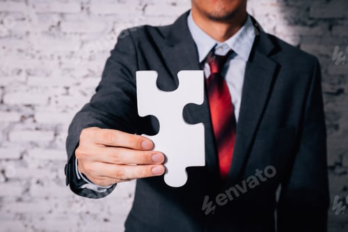 Preview: Business man giving the missing piece of jigsaw as offering a success