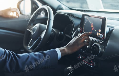 Preview: Side view. Young african american businessman in black suit is in the automobile