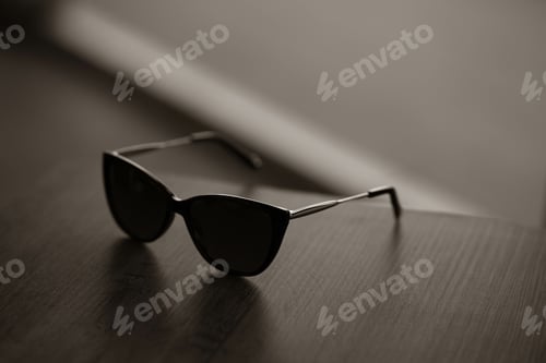 Preview: Closeup shot of brown wayfarer style sunglasses on a wooden table
