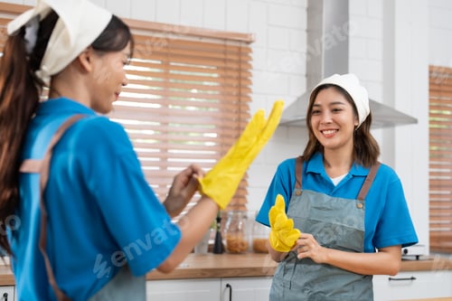 Preview: Asian women cleaning service team put on yellow rubber gloves prepare to housework in kitchen room
