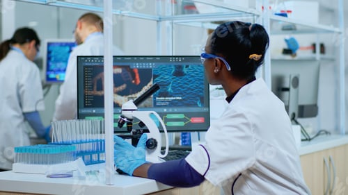 Preview: African woman scientist using microscope in modern lab