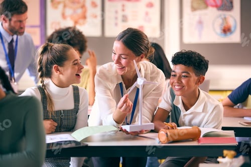 Preview: Female Teacher Helping Secondary Or High School Students Studying Wind Turbines In Science Class