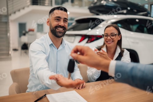 Preview: Satisfied pair receives keys to their new car from the dealer.