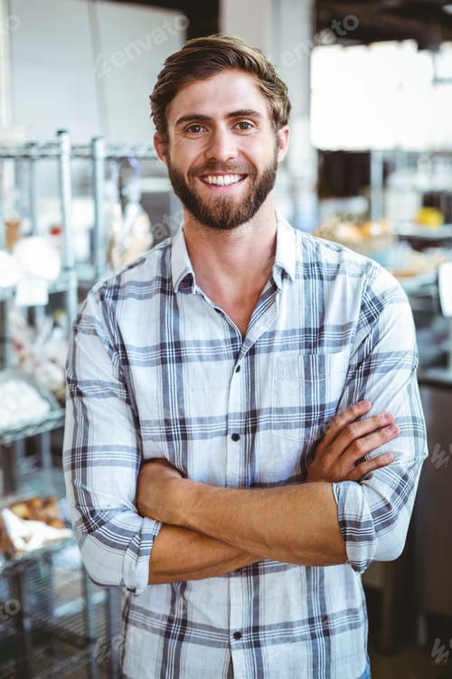 Preview: Selfassured waiter smiling in front of his bakery