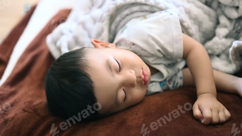 Preview: Close up view of baby boy sleeping on bed at home.