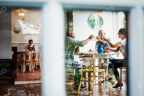 Preview: View through a window into a cafe, people sitting at tables.