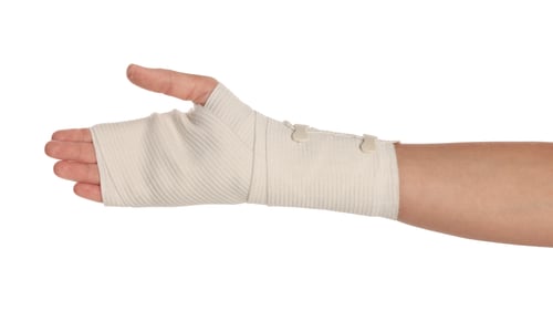 Preview: Woman with hand wrapped in medical bandage on white background, closeup