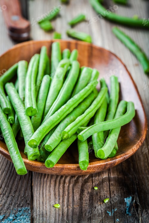 Preview: pods of fresh organic green beans in a wooden bowl closeup