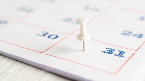 Preview: White thumbtack on a calendar page.