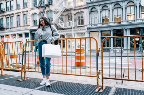 Preview: Happy female standing on street and calling on cellphone