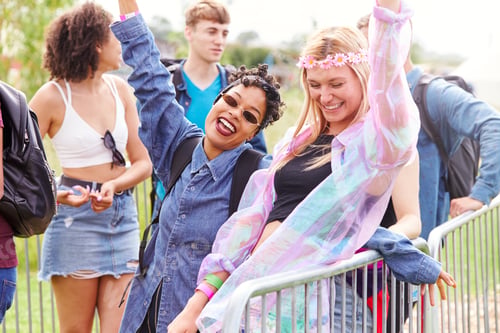 Preview: Portrait Of Female Friends Waiting Behind Barrier At Entrance To Music Festival Site