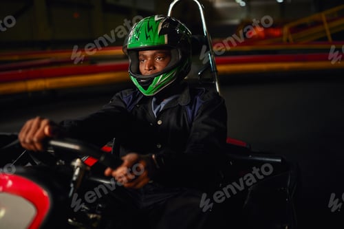 Preview: african american go kart driver in helmet driving on indoor circuit, speed racing challenge