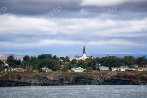 Preview: Residential homes on a rocky coast during a cloudy day