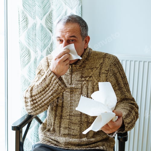 Preview: Man suffering from cold sneezes and blows nose