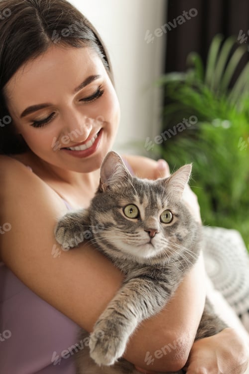 Preview: Young woman with cute cat at home. Pet and owner
