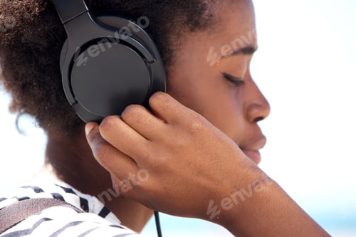 Preview: Close up young african american female listening music on headphone