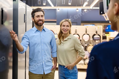 Preview: A couple engaging enthusiastically with a knowledgeable appliance salesperson in a modern store