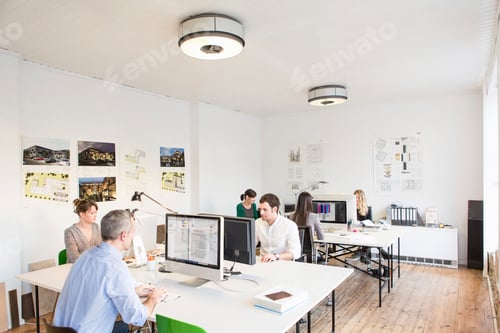 Preview: Colleagues in office sitting at desks using computers
