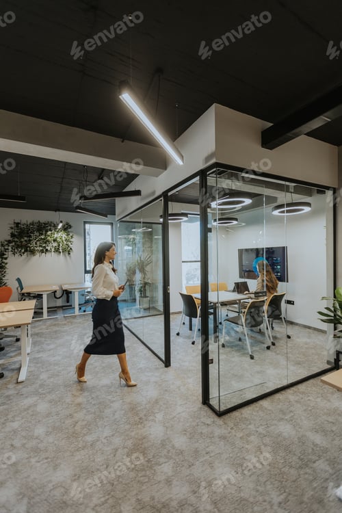 Preview: Young woman with digital tablet walking in the modern office